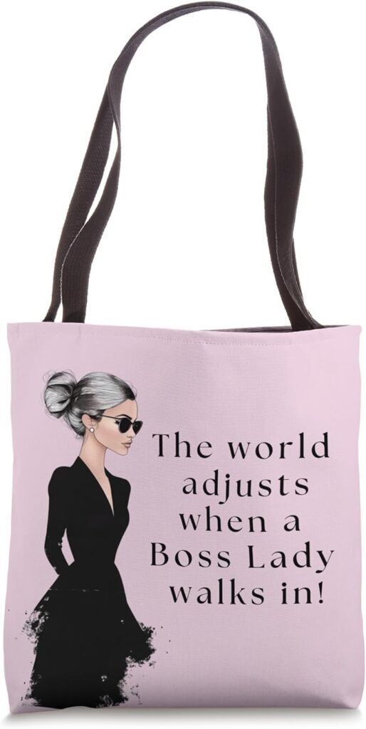 Stylish boss lady bag with an empowering quote, featuring a confident woman in black and a soft pink background.